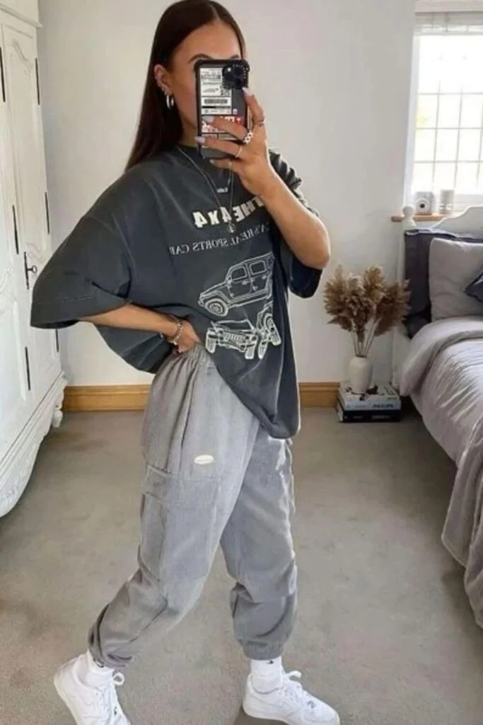 This image is of a comfy college outfit of greay sweatpants and an oversized T shirt with chunky white shoes