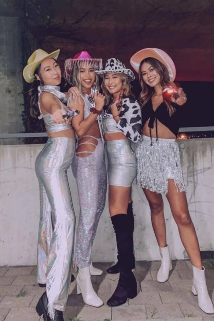 This image is of a group of college friends dressed up as galactic cowgirls for halloween. They are wearing all white and silver with cowboy hats