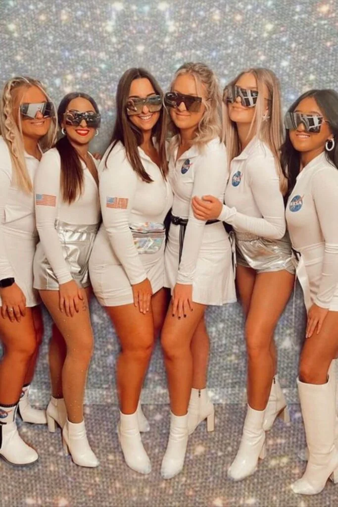 This image is of a group of college friends dressed up as NASA astronauts for halloween. They are wearing all white and silver boots.