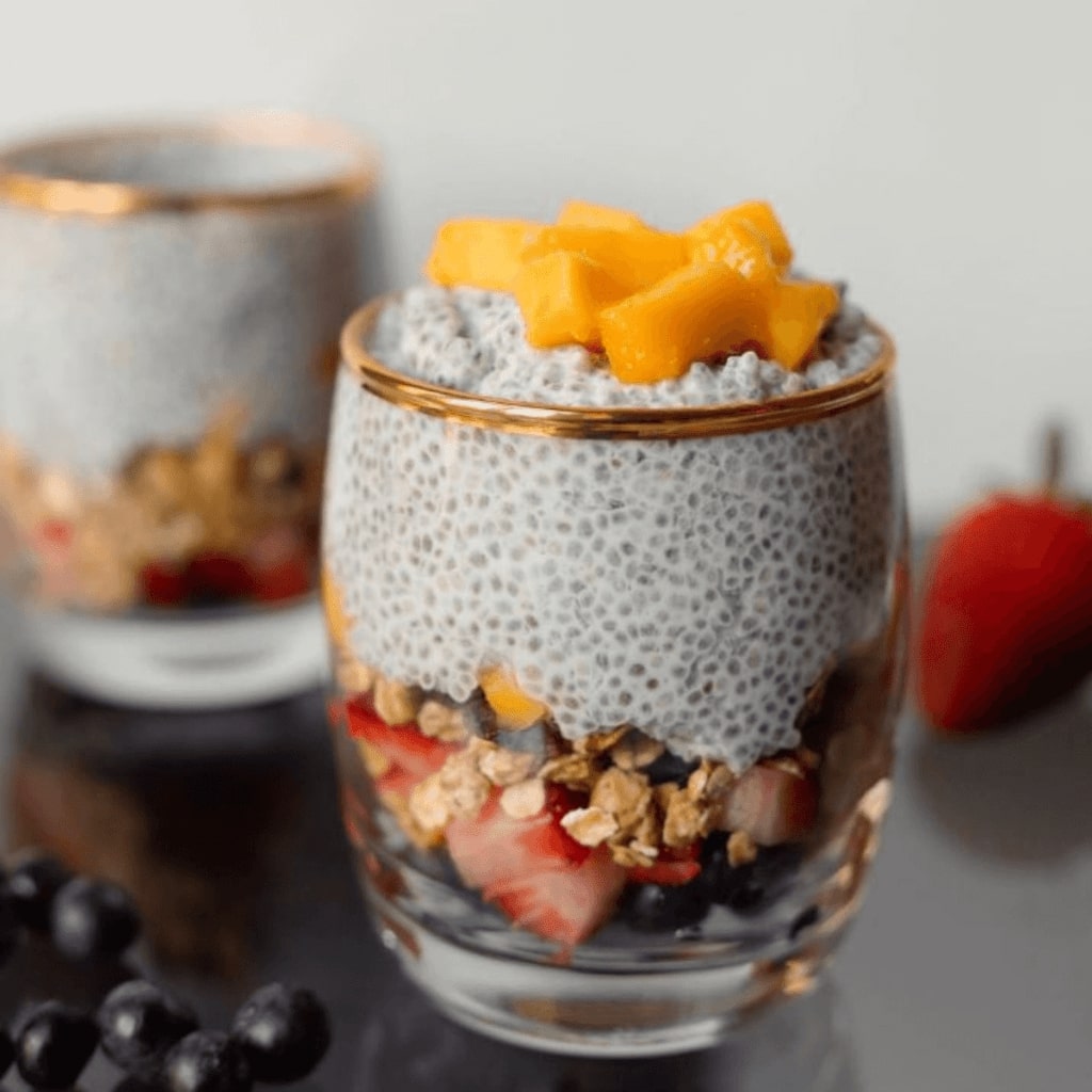 This image is of a chia seed pudding with granola and fruit in a portable glass. Perfect for on the go.
