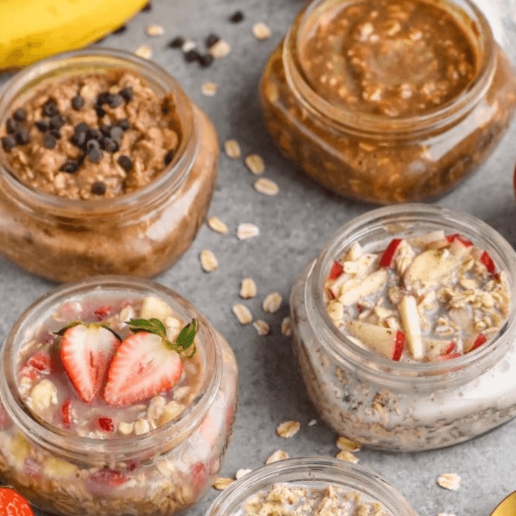 This image is of overnight oats in containers that are perfect to grab and go for any busy college student. They vary from a strawberry topping to a peanut butter or apple flavors.