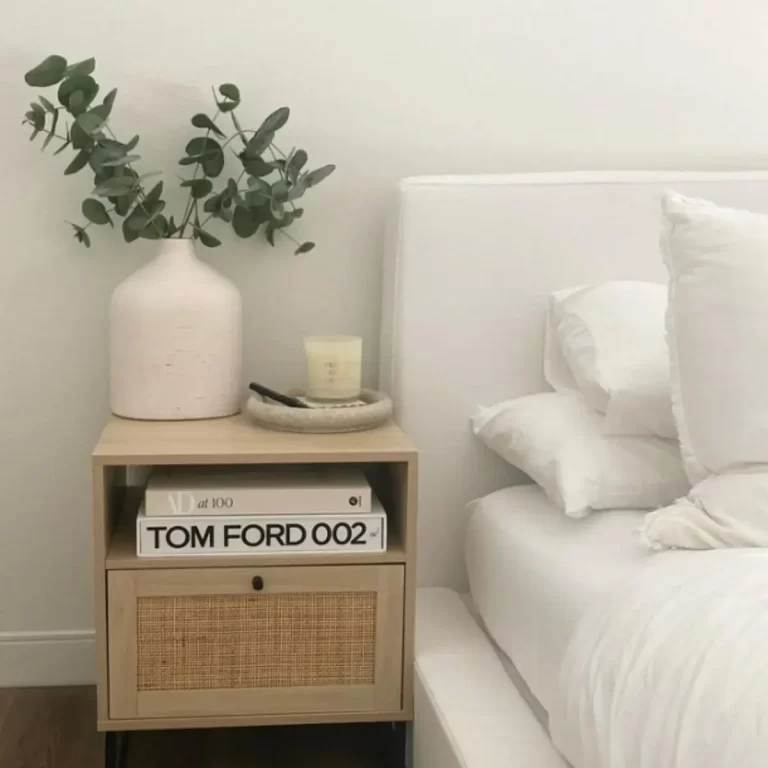 this photo is of a nightstand decorated with books and a plant