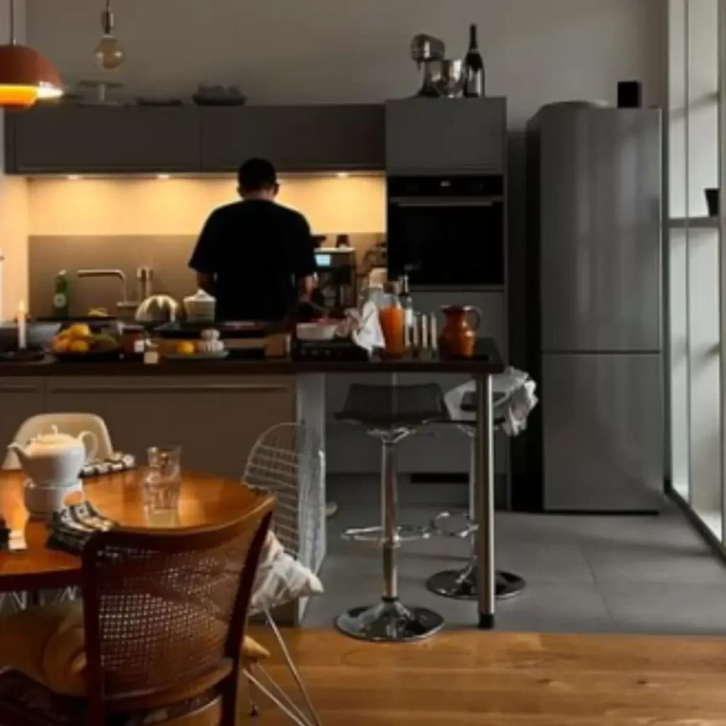 This image is of a friend cooking in a kitchen with lots of fruit and food for entertaining