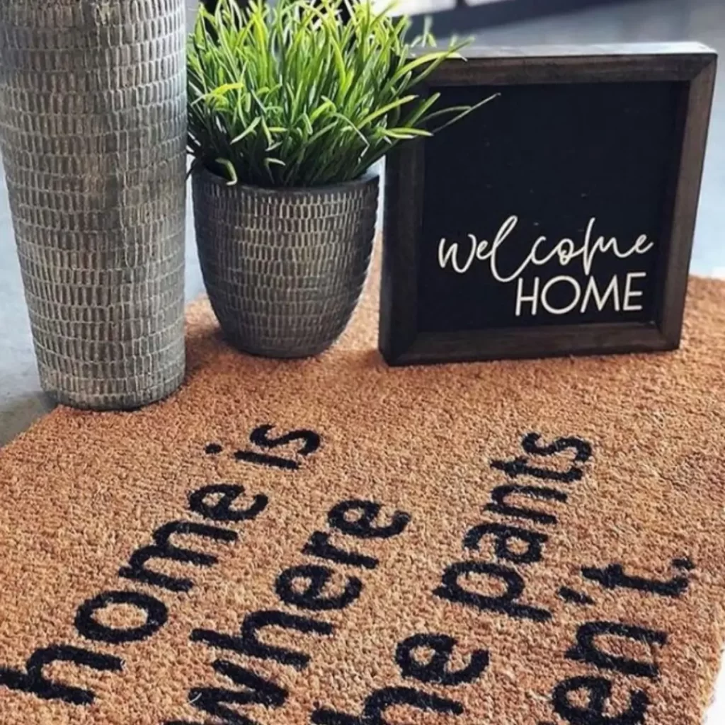 Image of a doormat and signs with a plant for decor