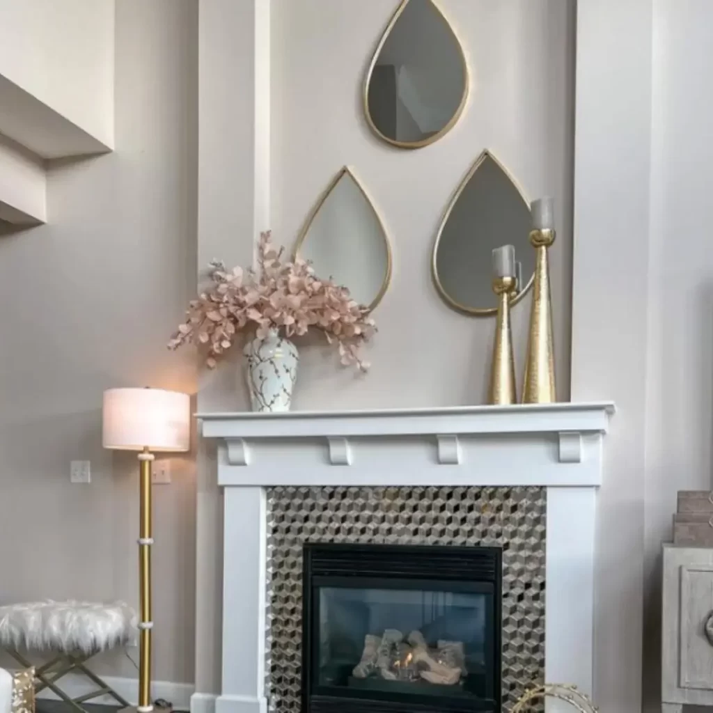 image of a teardrop shaped mirror collage over a mantle fireplace